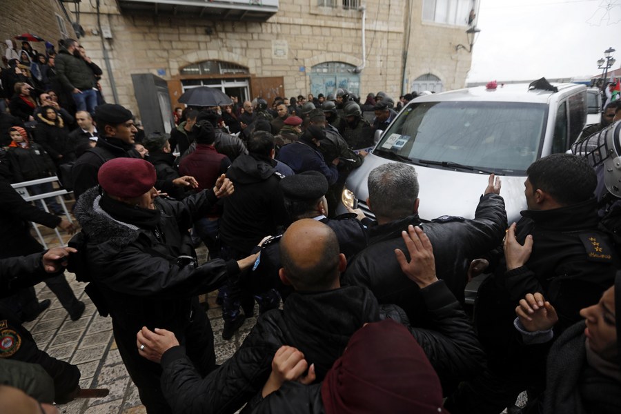 epa06419922 Palestinian security forces push away demonstrators from the convoy of Greek Orthodox Patriarch of Jerusalem Theophilos III, during a protest against his visit in the West Bank city of Bethlehem, 06 January 2018. EPA/ABED AL HASHLAMOUN