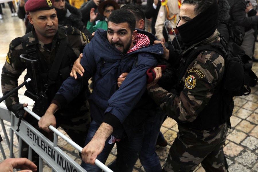 epa06419921 Palestinian security forces push away demonstrators from the convoy of Greek Orthodox Patriarch of Jerusalem Theophilos III, during a protest against his visit in the West Bank city of Bethlehem, 06 January 2018. EPA/ABED AL HASHLAMOUN