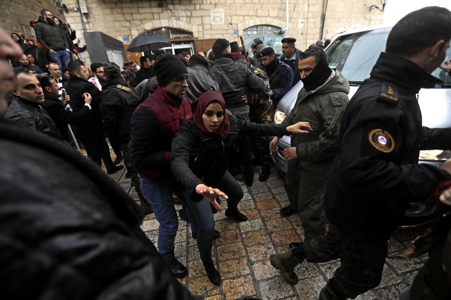 epa06419925 Palestinian security forces push away demonstrators from the convoy of Greek Orthodox Patriarch of Jerusalem Theophilos III, during a protest against his visit in the West Bank city of Bethlehem, 06 January 2018. EPA/ABED AL HASHLAMOUN