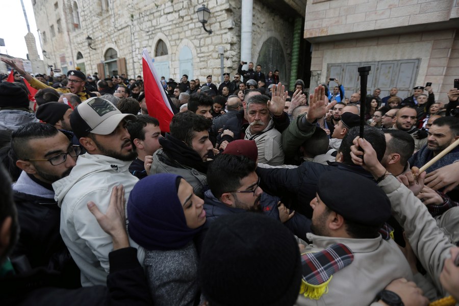 epa06419926 Palestinian security forces push away demonstrators from the convoy of Greek Orthodox Patriarch of Jerusalem Theophilos III, during a protest against his visit in the West Bank city of Bethlehem, 06 January 2018. EPA/ABED AL HASHLAMOUN