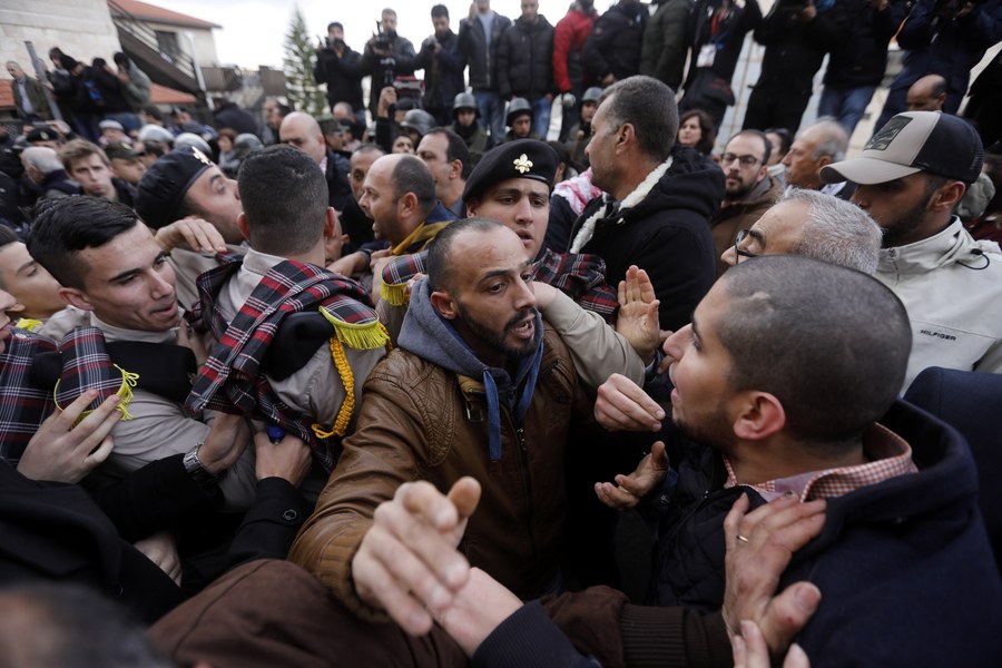 epa06419924 Palestinian security forces push away demonstrators from the convoy of Greek Orthodox Patriarch of Jerusalem Theophilos III, during a protest against his visit in the West Bank city of Bethlehem, 06 January 2018. EPA/ABED AL HASHLAMOUN